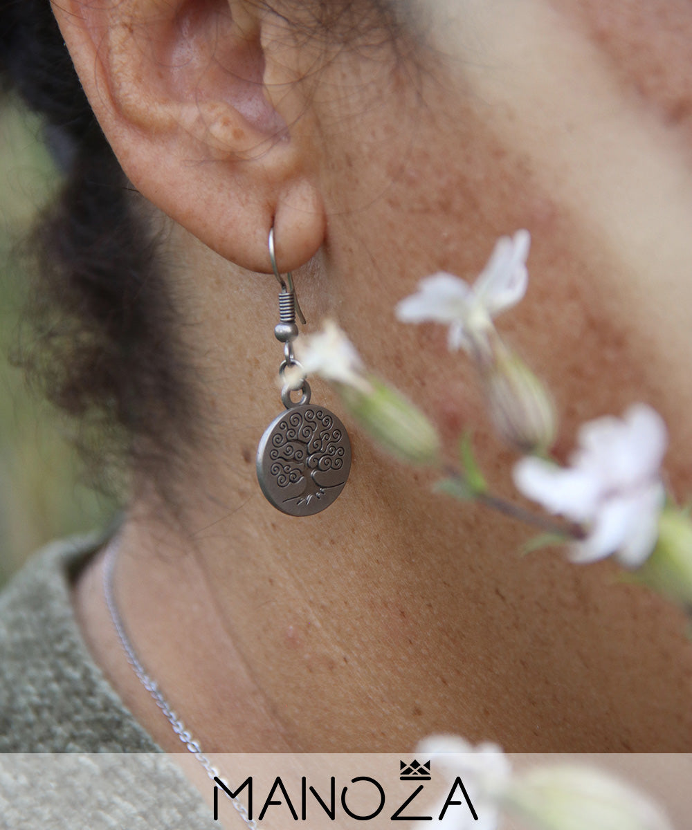 une boucle d'oreille médaille arbre de vie