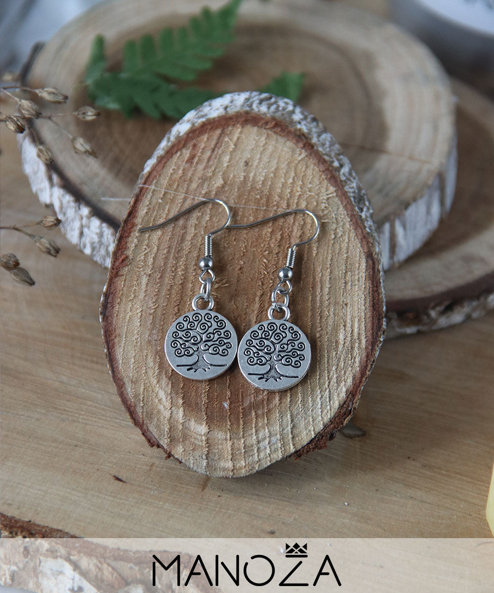 des boucles d'oreilles médaille arbre de vie sur bois